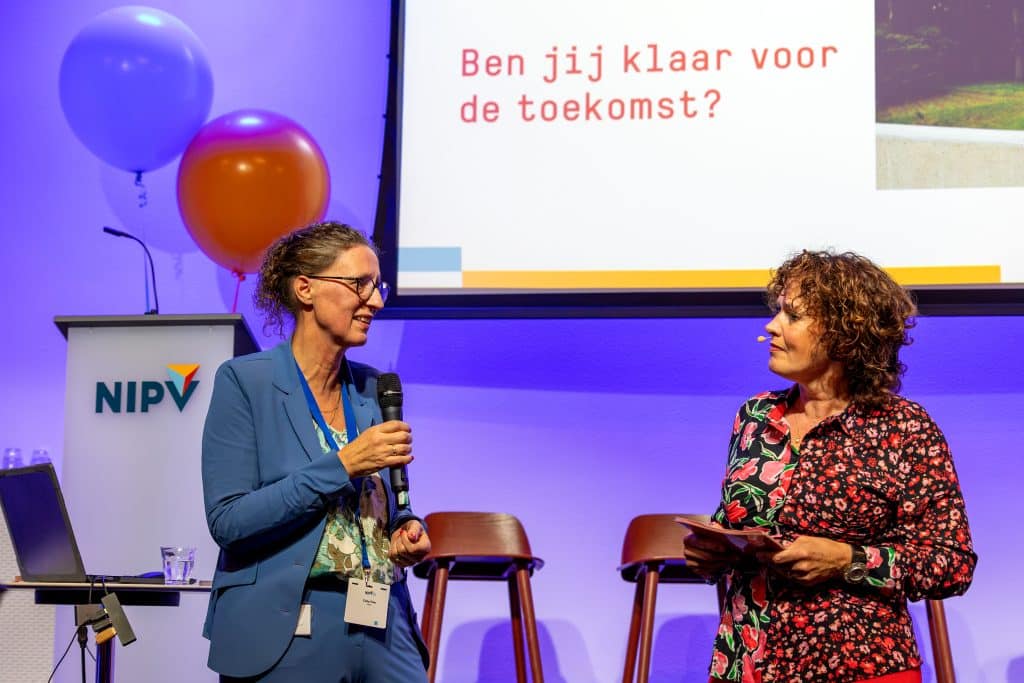 Coby Flier, directeur onderzoek en onderwijs van het NIPV, in gesprek met dagvoorzitter Marlies Claasen tijdens de opening van het onderwijsjaar 2024-2025.