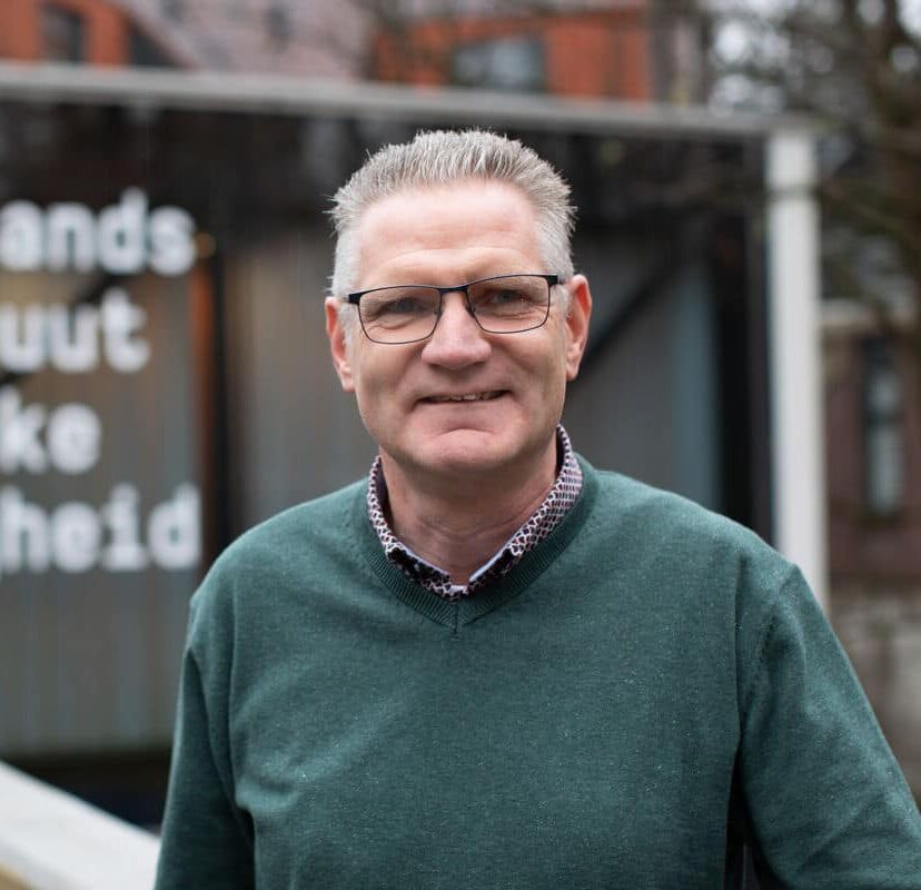 Willem Treurniet staat voor het gebouw van het NIPV