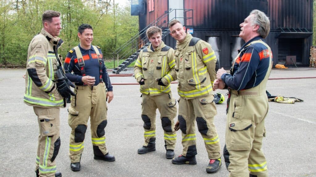 Brandweermensen in gesprek op oefenlocatie.