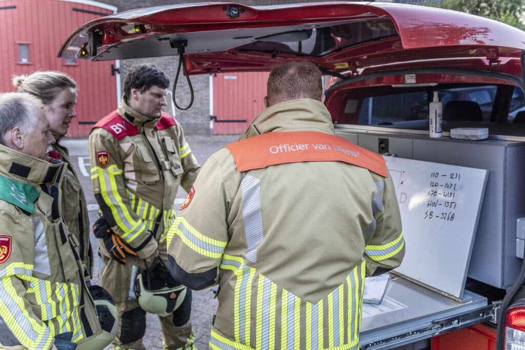 Officier van dienst (OvD) in gesprek met collega's.
