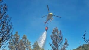 Een Catalaanse blushelikopter loost water boven een natuurbrand.