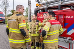 Brandweermensen in gesprek met elkaar voor tankautospuit